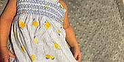 Maritza joined the competition — help win amazing prizes! baby, infant, dress, clothing, blanket, pacifier, lying_down, face, skin, cute, child, newborn, patterned_dress, striped, yellow, soft_texture, indoors, person, baby_girl, curious