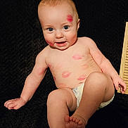 Blake is registered to the contest to win money with this photo: baby, infant, diaper, face, skin, lipstick, kiss_marks, smile, happy, blue_eyes, bare_chest, cheeks, hand, foot, toes, sitting, texture, background, light, cute