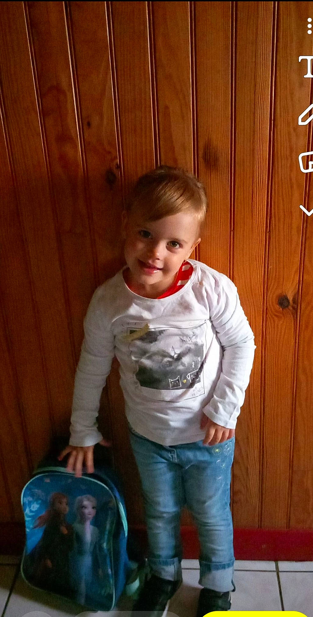 Melina a rejoint le concours — aidez-le/la à gagner de superbes lots ! baby_toddler_clothing, cheek, child, denim, door, electric_blue, flooring, fun, happy, hardwood, jeans, joy, pattern, person, sitting, sleeve, smile, t_shirt, toddler, varnish