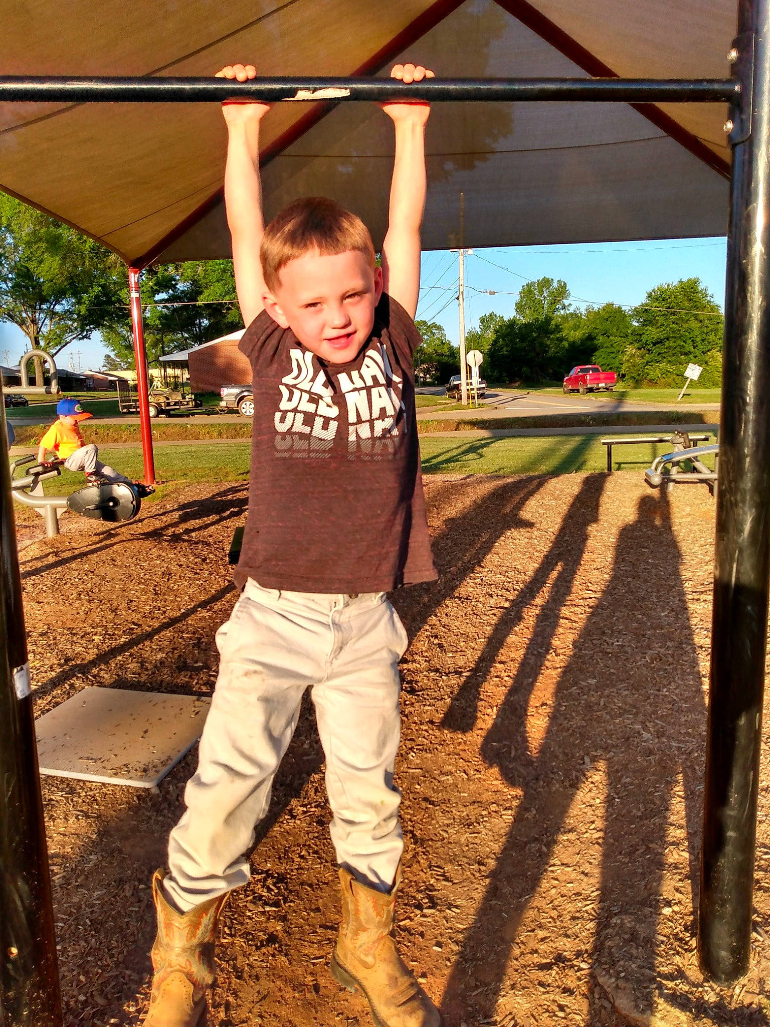 Layne joined the competition — help win amazing prizes! flash_photography, fun, gesture, grass, hairstyle, happy, joy, leisure, outdoor_play_equipment, people_in_nature, person, recreation, shade, smile, soil, standing, swing, t_shirt, tints_and_shades, toddler