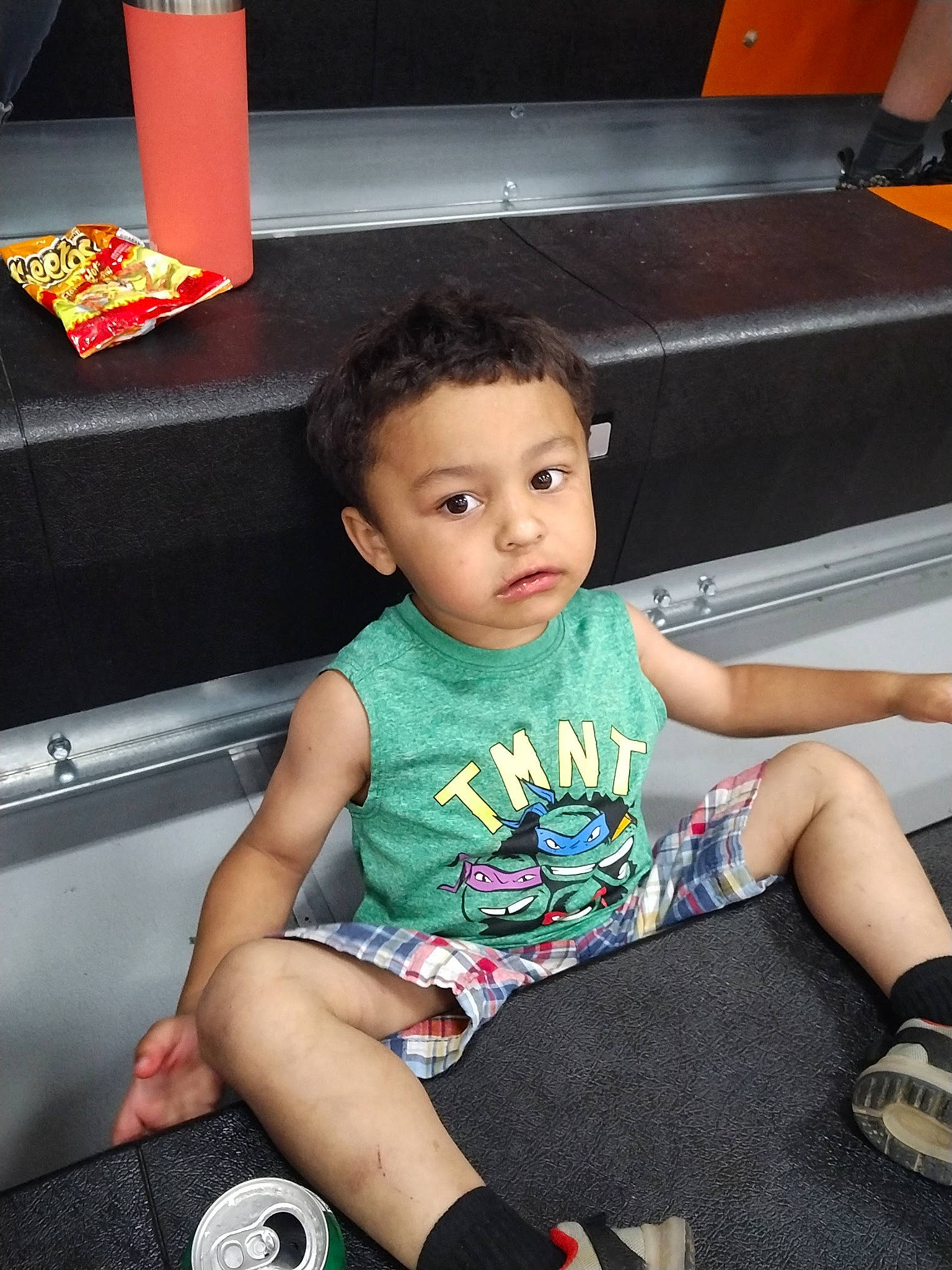 Trevor is registered to the contest to win money with this photo: beauty, black, child, electronic_device, flash_photography, fun, gadget, happy, human_leg, lap, leisure, person, shoe, shorts, sitting, snapshot, sneakers, t_shirt, technology, thigh