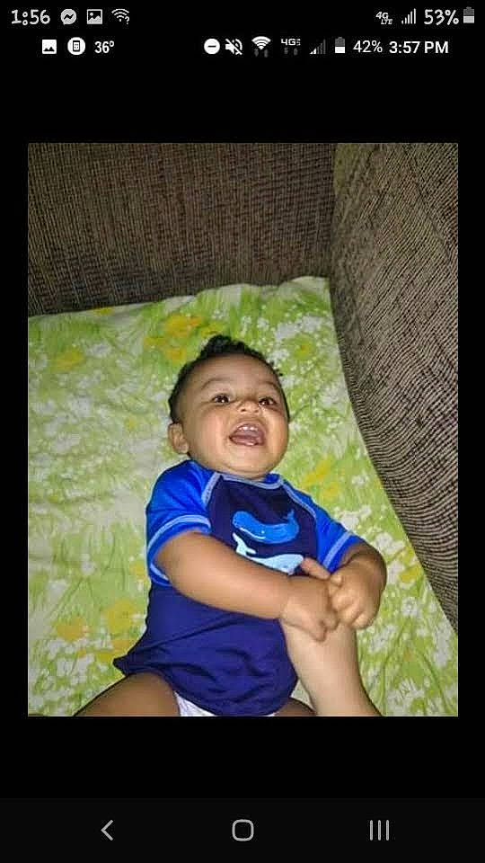 Trevor is registered to the contest to win money with this photo: baby, child, darkness, display_device, electric_blue, flash_photography, fun, grass, happy, leisure, people_in_nature, person, plant, room, sitting, smile, t_shirt, tints_and_shades, toddler, tree