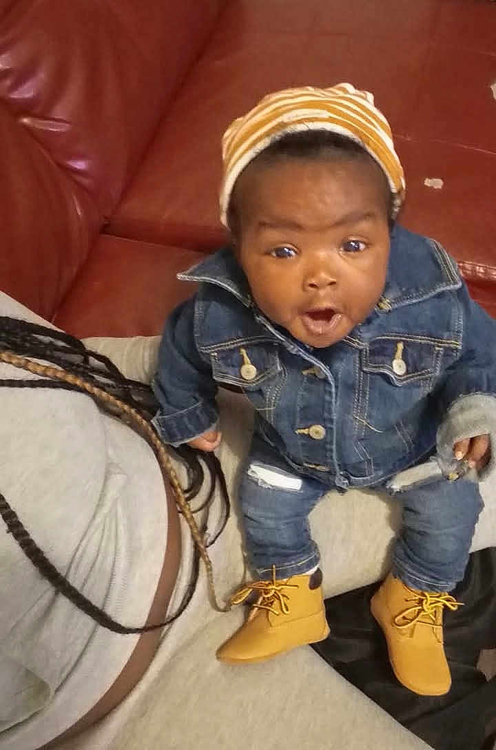 Millie joined the competition — help win amazing prizes! baby, child, denim_jacket, denim_jeans, beanie, boots, couch, leather, person, braids, hair, indoor, surprised_expression, sitting, clothing, casual, young_child, face, portrait, cozy