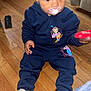 Hartley joined the competition — help win amazing prizes! toddler, child, pacifier, toy, sitting, wooden_floor, blue_outfit, cartoon_print, indoor, home, curly_hair, sock, flooring, furniture, person, young_child, cute, casual_clothing, playtime, expression