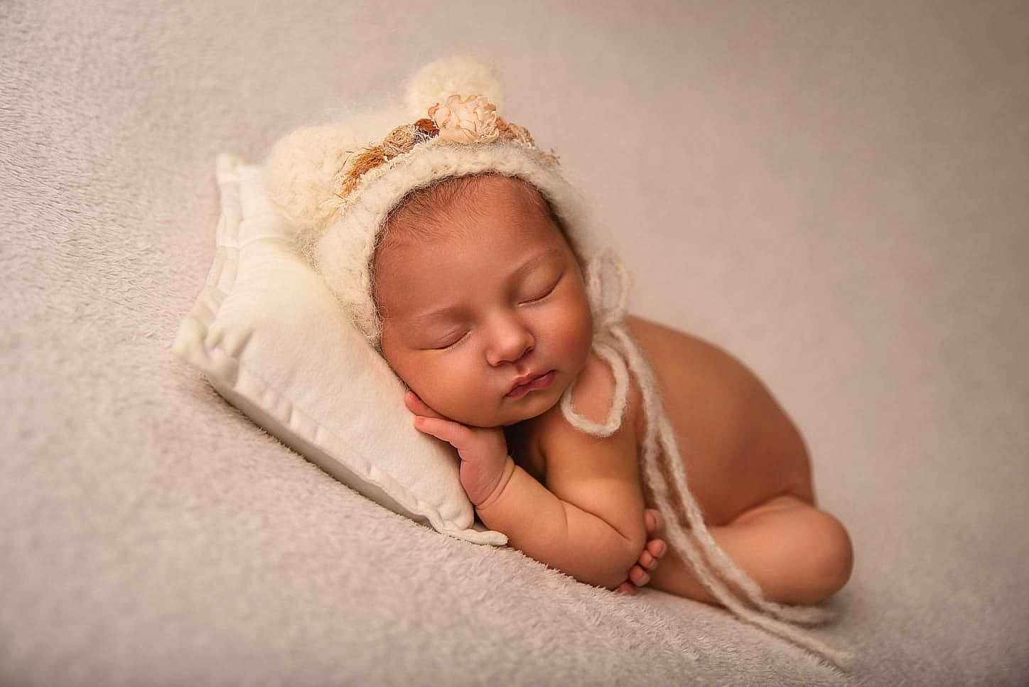 Shelby participe au concours pour gagner de l'argent avec cette photo : baby, newborn, sleeping, hat, pillow, blanket, soft_texture, peaceful, infant, resting, cute, portrait, cozy, warm_tones, skin, child, knitted_hat, pom_poms, flower, toddler