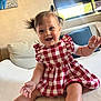 Athenais a rejoint le concours — aidez-le/la à gagner de superbes lots ! baby, bright, child, couch, cute, dress, furniture, happy, home, indoor, infant, living_room, person, pigtails, pillow, portrait, red_and_white_checkered, seated, smiling, window