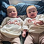 baby, infant, twin, cute, smiling, sweater, clothing, bed, pillow, window, natural_light, indoor, face, person, child, happy, cozy, soft, lying_down, matching_outfits
