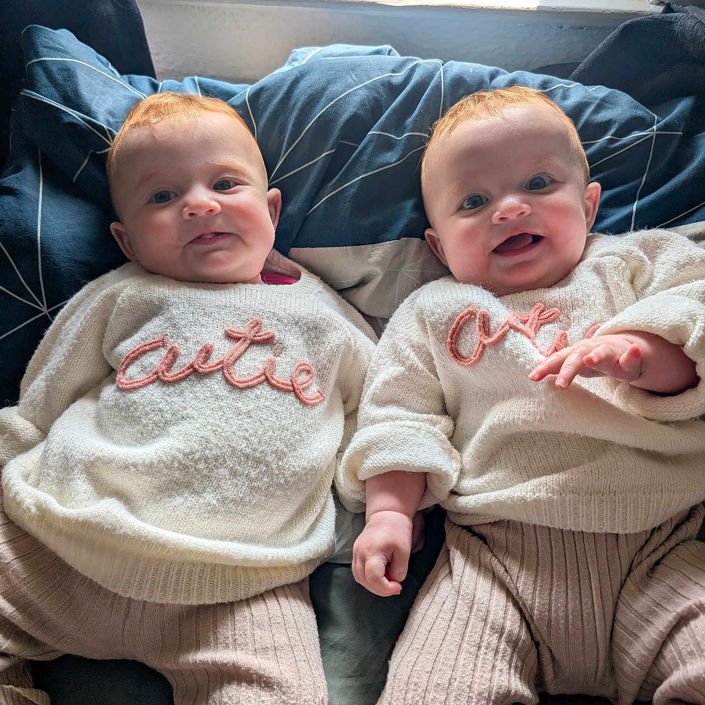 Nancy And Maggie joined the competition — help win amazing prizes! baby, bed, child, clothing, cozy, cute, face, happy, indoor, infant, lying_down, matching_outfits, natural_light, person, pillow, smiling, soft, sweater, twin, window