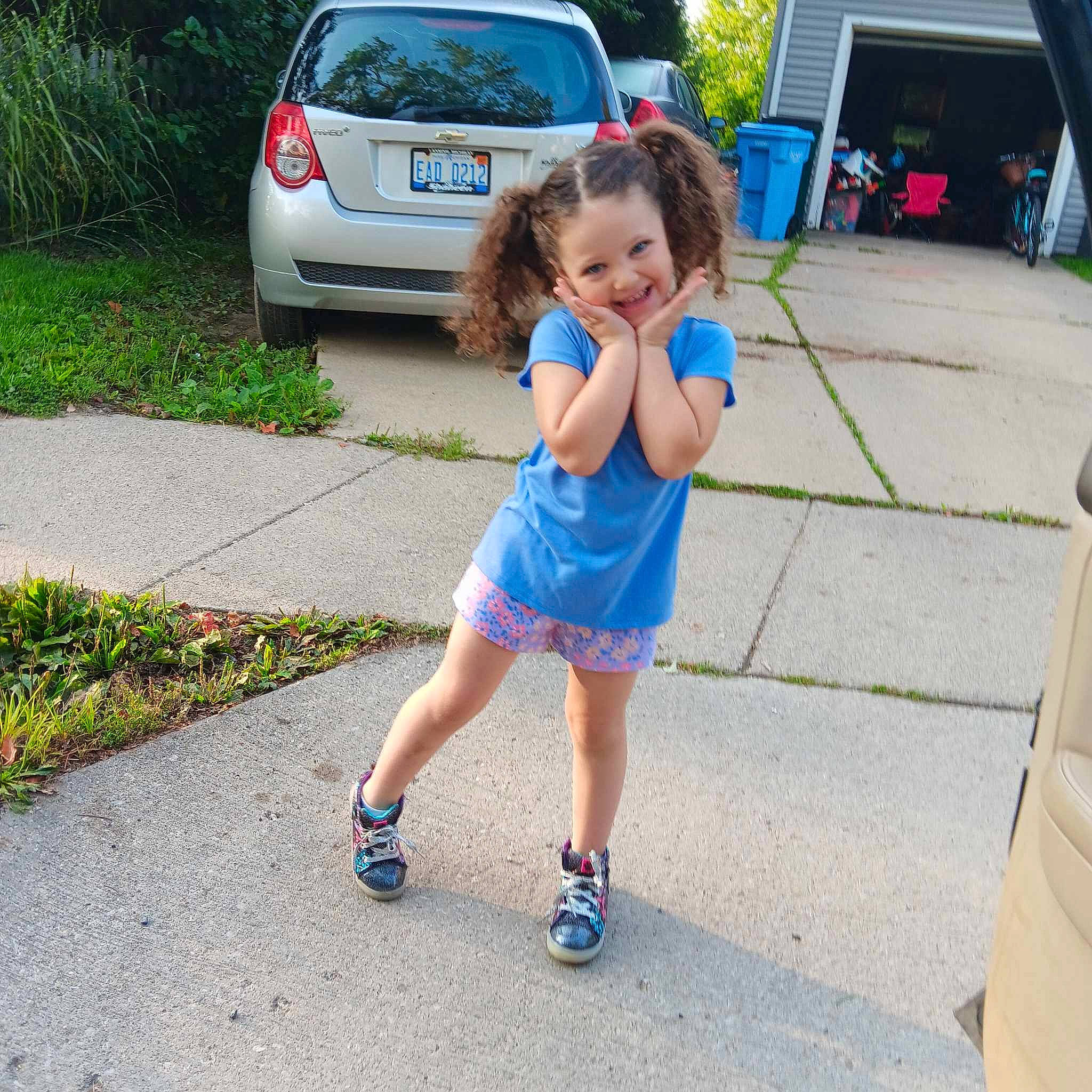 A'Mariyana is registered to the contest to win money with this photo: asphalt, automotive_exterior, car, electric_blue, fun, grass, joy, leisure, motor_vehicle, parking, person, plant, recreation, road, road_surface, shorts, sidewalk, tire, toddler, tree