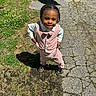 child, toddler, outdoor, portrait, smiling, standing, pink_outfit, vest, bow_tie, braids, dress_shoes, driveway, grass, parked_car, sunlight, shadow, pavement, fashion, cute, daylight