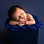 baby, newborn, sleeping, blue_blanket, knit_blanket, portrait, studio, infant, peaceful, closed_eyes, face, head, hair, hands, bracelet, box, prop, soft_lighting, cozy, photography