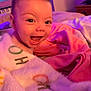 baby, babylaughing, bed, bedroom, blanket, bodypart, face, furniture, happy, head, indoors, laughing, person, photography, portrait, purple, quilt, room, skin, tattoo