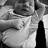 baby, infant, sleeping, portrait, black_and_white, close_up, face, eyes_closed, peaceful, relaxed, onesie, blanket, fabric, hand, fist, arm, cushion, sunlight, indoor, photography