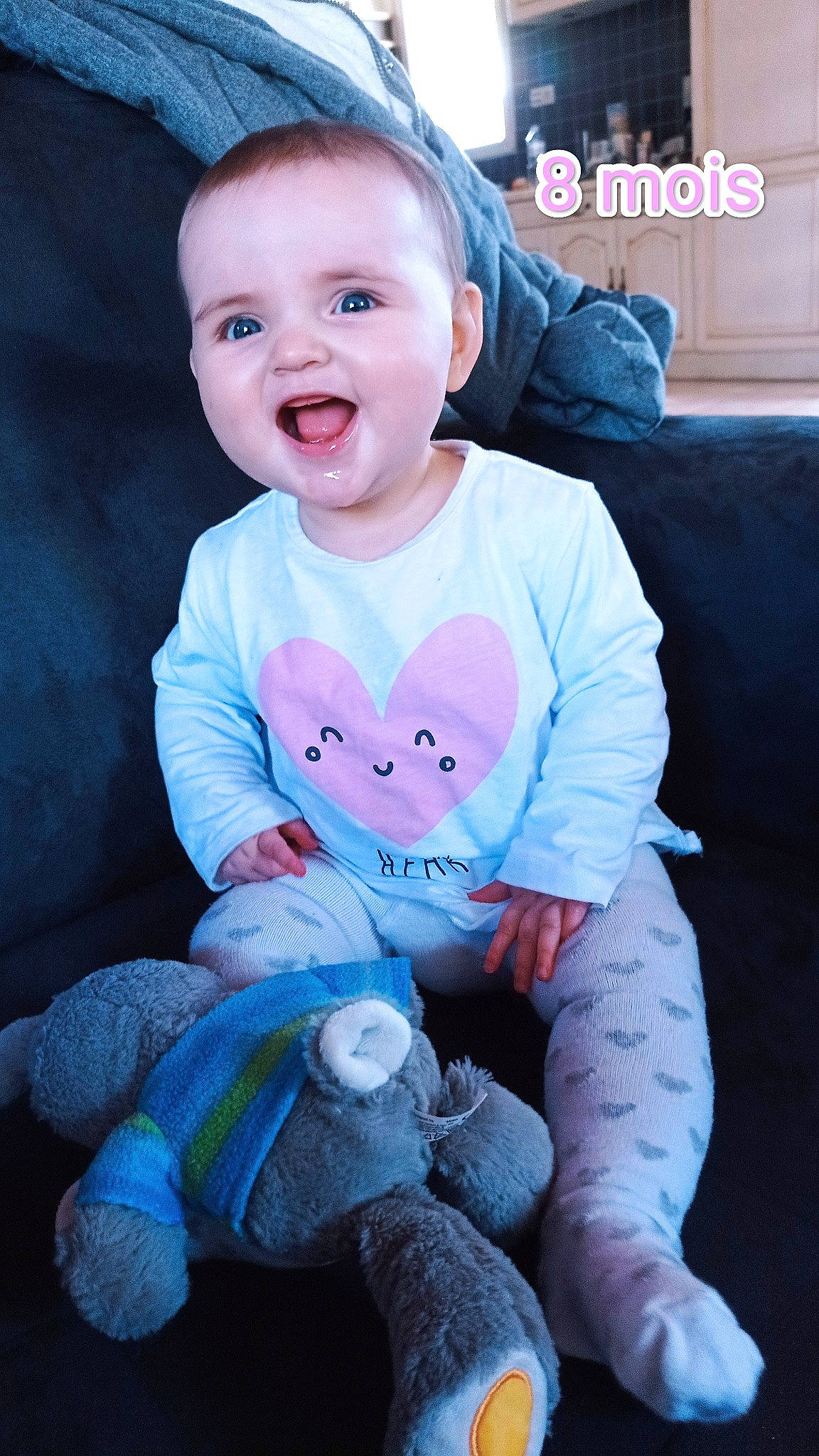 Léonie a rejoint le concours — aidez-le/la à gagner de superbes lots ! arm, baby, baby_toddler_clothing, blue, cheek, couch, eye, face, finger, flash_photography, happy, head, person, pink, purple, skin, sleeve, smile, textile, toddler