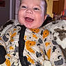 Kaysen is registered to the contest to win money with this photo: baby, child, infant, smiling, happy, portrait, close_up, face, eyes, open_mouth, seated, onesie, pajamas, pumpkin_pattern, cat_pattern, halloween, blanket, cushion, indoor, kitchen