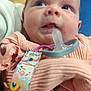 baby, infant, pacifier, clothing, closeup, indoor, person, blue_eyes, hand, fabric, cute, child, expression, soft_lighting, holding, colorful, pacifier_clip, skin, young, portrait