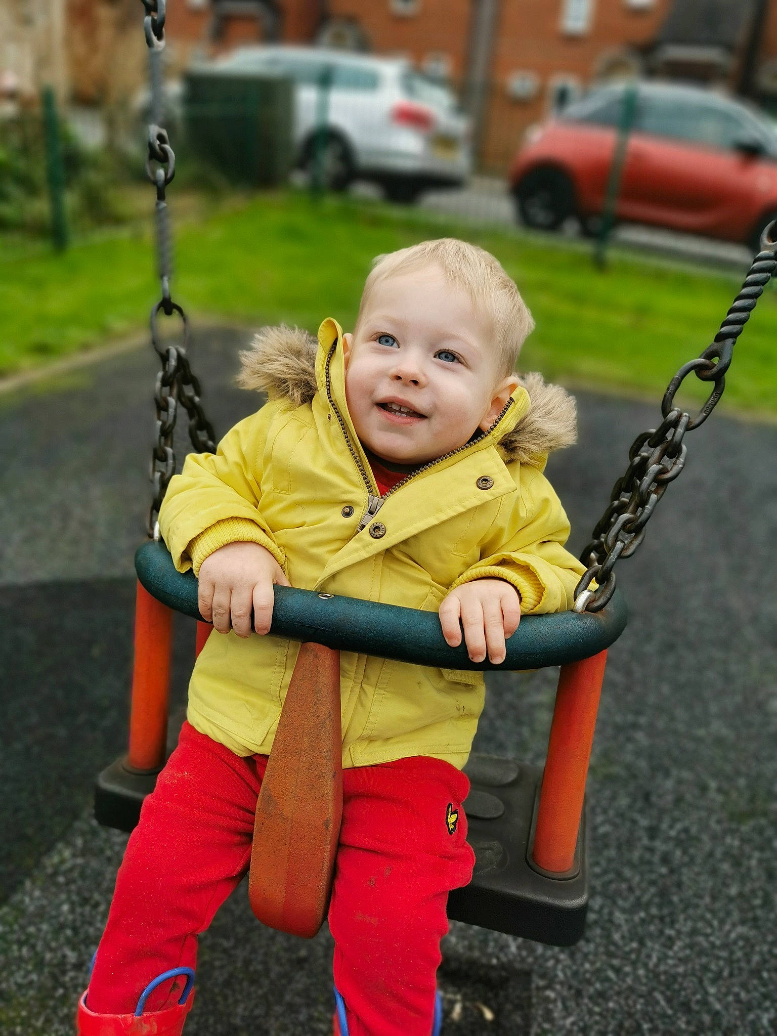 Victor is registered to the contest to win money with this photo: baby, car, child, fun, grass, happy, human_settlement, joy, leisure, person, playground, product, public_space, recreation, smile, sneakers, standing, swing, tire, toddler