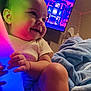Vivian joined the competition — help win amazing prizes! baby, child, colorful_light, glowing_tube, blanket, television, room, indoor, smiling, happy, skin, arm, leg, hand, cozy, fan, wall, ceiling, furniture, night