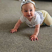Freya joined the competition — help win amazing prizes! baby, carpet, casual_clothing, child, crawling, cute, floor, hands, happy, headband, home, indoor, living_room, person, portrait, smiling, sofa, white_top, yellow_pants, young_child