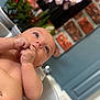 Eris is registered to the contest to win money with this photo: baby, infant, bath, water, skin, hand, face, eyes, indoor, flower, plant, brick_wall, blue_wall, tub, relaxation, cute, portrait, child, newborn, thoughtful