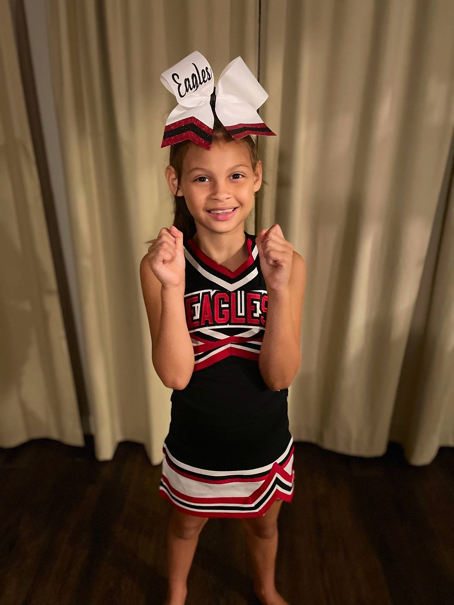 Giana is registered to the contest to win money with this photo: baseball_cap, cap, curtain, event, face, flash_photography, flooring, fun, happy, hat, headwear, human_leg, joy, person, sleeve, smile, sports_uniform, sportswear, standing, t_shirt