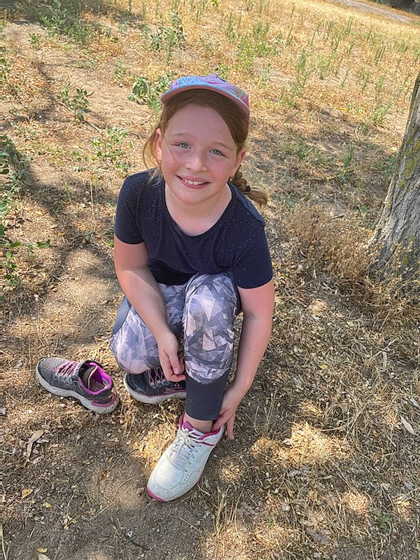 Emma participe au concours pour gagner de l'argent avec cette photo : baseball_cap, cap, cool, electric_blue, finger, footwear, fun, grass, happy, hat, human_leg, joy, knee, landscape, people_in_nature, person, sleeve, smile, t_shirt, thigh