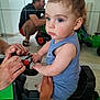 Léon a rejoint le concours — aidez-le/la à gagner de superbes lots ! toddler, child, toy_tractor, blue_eyes, indoor, mirror, reflection, hands, adult, floor, casual_clothing, person, shorts, tank_top, playing, support, footwear, home, light, curly_hair