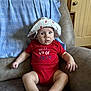 Harley joined the competition — help win amazing prizes! baby, infant, red_onesie, hat, sitting, couch, blanket, indoor, door, curious, child, portrait, celebration, comfortable, home, furniture, cute, skin, expression, face