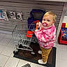 Savannah joined the competition — help win amazing prizes! child, toddler, shopping_cart, pacifier, pink_jacket, winter_clothing, blond_hair, blue_eyes, standing, indoors, store, retail, display, toys, hot_wheels, floor_tiles, entrance_mat, smiling, portrait, candid