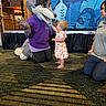 toddler, child, mascot, wolf, costume, animal, meeting, greeting, indoor, event, staff_member, dress, colorful_clothing, barefoot, smiling, carpet, stage, backdrop, family_friendly, woodland_theme