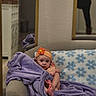 Daphne joined the competition — help win amazing prizes! baby, blanket, couch, pillow, flower_pattern, headband, orange, purple, infant, child, indoor, mirror, reflection, person, foot, soft_texture, cozy, furniture, curious, seated