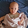 Daphne is registered to the contest to win money with this photo: baby, child, blanket, blue_sheet, curious, face, infant, indoors, looking, person, portrait, resting, soft_texture, wrapped, young_child, wide_eyes, skin, head, hand, expression