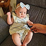 baby, child, infant, girl, dress, headband, bow, sitting, hand, finger, armchair, furniture, indoor, cute, portrait, person, skin, expression, comfort, holding