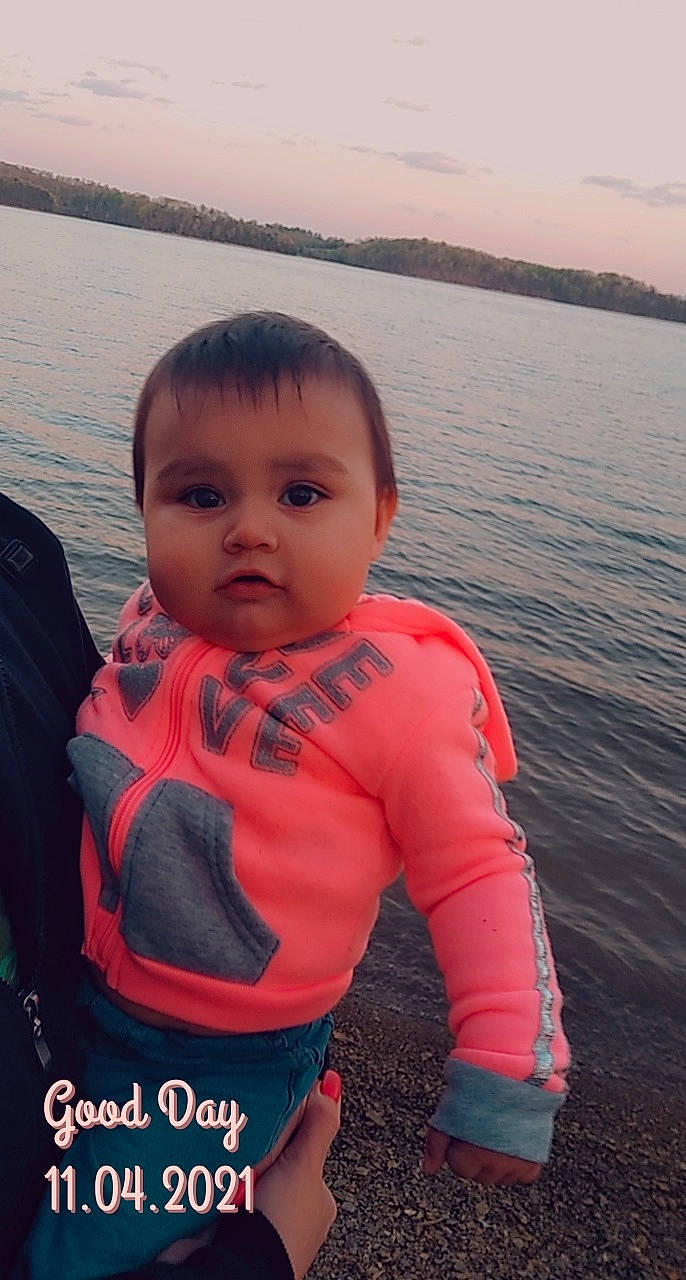 Mia Marie is registered to the contest to win money with this photo: baby_toddler_clothing, chin, eye, flash_photography, hair, happy, head, iris, lake, lip, neck, nose, person, personal_protective_equipment, skin, sky, sleeve, summer, toddler, travel