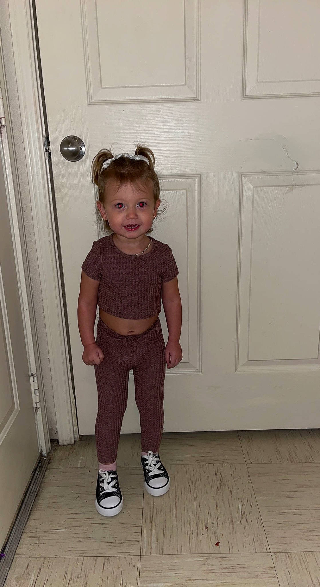 Ava-grace is registered to the contest to win money with this photo: arm, baby_toddler_clothing, child, clothing, door, floor, flooring, hair, hardwood, joint, knee, leg, pattern, person, shoulder, sleeve, standing, sunglasses, toddler, waist