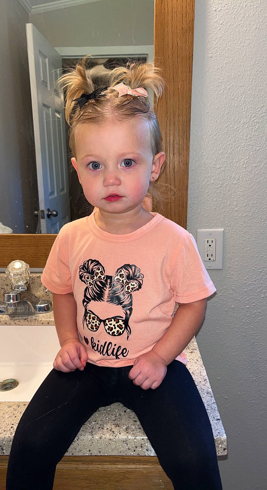 Ava-grace is registered to the contest to win money with this photo: baby_toddler_clothing, cheek, child, chin, eyelash, eyewear, flooring, fun, hair, happy, long_sleeved_t_shirt, neck, pattern, person, pink, sitting, skin, sleeve, standing, t_shirt