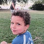 child, boy, smile, grass, tree, park, blanket, outdoor, nature, curly_hair, shorts, tshirt, sky, greenery, person, daylight, play, relax, fun, casual