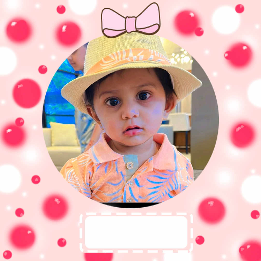 Ahilan joined the competition — help win amazing prizes! background_blur, big_eyes, bow, casual, child, curious, cute, face, fashion, hat, indoor, orange_shirt, patterned_shirt, person, pink_background, portrait, red_dots, smile, straw_hat, toddler