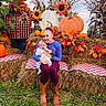 Meridith is registered to the contest to win money with this photo: baby, infant, mother, adult, child, portrait, smiling, sitting, outdoor, autumn, fall, pumpkins, sunflowers, hay_bales, corn_stalks, autumn_leaves, plaid_blanket, harvest, family, nature