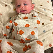 Meridith joined the competition — help win amazing prizes! baby, infant, child, portrait, smiling, happy, lying_down, blanket, onesie, pumpkin_pattern, polka_dots, clothing, face, eyes, hair, indoor, cozy, couch, soft_blanket, photography
