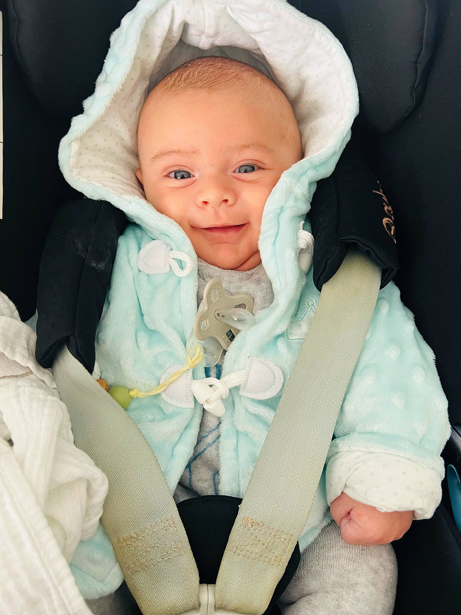 Maël a rejoint le concours — aidez-le/la à gagner de superbes lots ! baby, baby_in_car_seat, baby_products, baby_safety, baby_toddler_clothing, cheek, child, comfort, eye, finger, human_body, linens, person, seat_belt, skin, sleeve, smile, textile, thumb, toddler