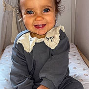 Alma participe au concours pour gagner de l'argent avec cette photo : bed, bottle, child, clothing, curly_hair, cute, face, happy, home, indoor, infant, long_sleeve, nursery, pants, person, portrait, sitting, smiling, toddler, toy