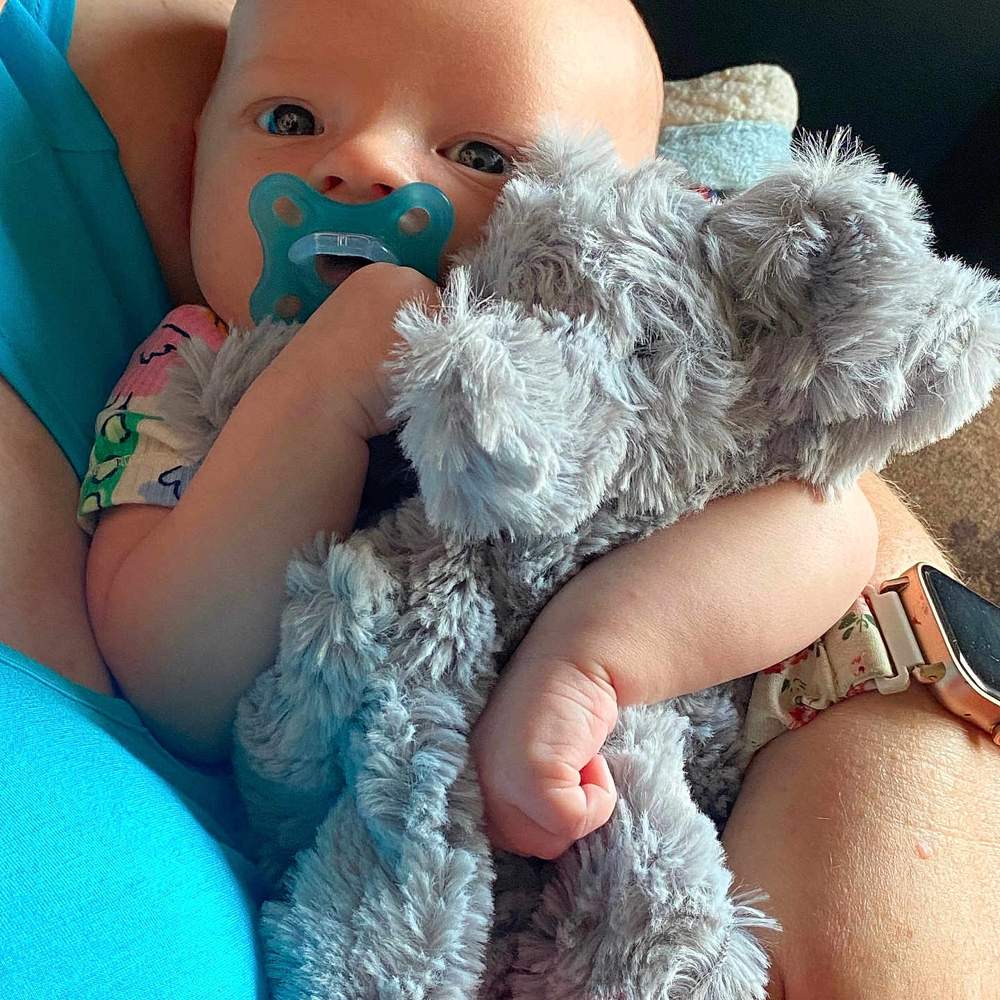 Skylar joined the competition — help win amazing prizes! arm, baby, blue_shirt, child, closeup, clothing, comfort, cuddly, elephant_toy, face, floral_watchband, hand, indoor, infant, pacifier, person, skin, soft_toy, stuffed_animal, watch