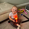 toddler, child, smiling, indoor, carpet, toy, balloon, ottoman, white_shirt, pants, socks, floor, home, play, colorful, light, glowing, happy, cute, person