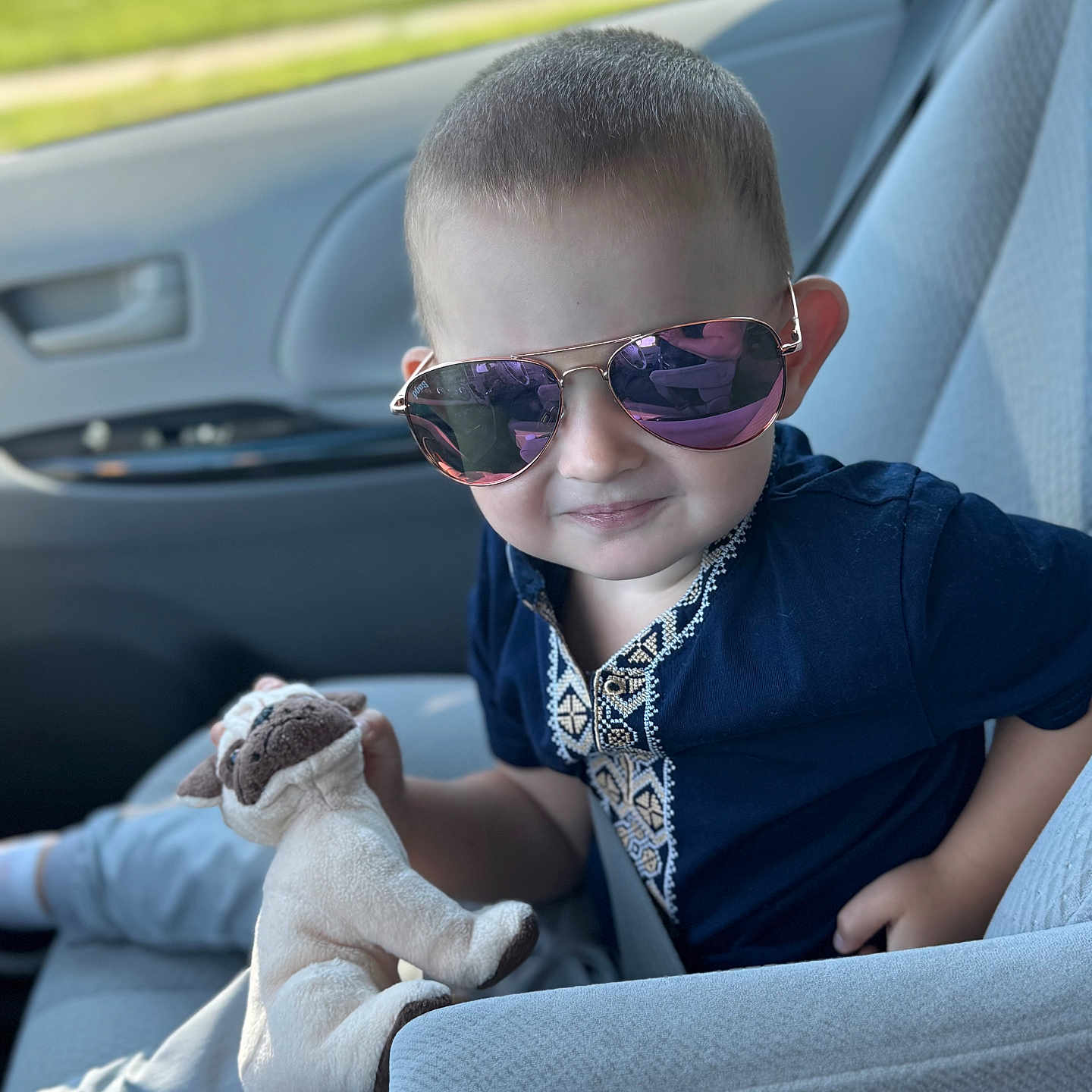 Maksym is registered to the contest to win money with this photo: blue_shirt, car_interior, car_seat, casual_clothing, child, cute, daylight, indoor, person, plush_toy, portrait, reflection, seatbelt, short_hair, smile, sunglasses, toddler, toy, window, young_child