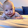Kyro is registered to the contest to win money with this photo: baby, smiling, blue_eyes, lying_down, bed, pillow, skin, arm, hand, infant, close_up, cute, happy, indoors, child, person, portrait, soft_light, support, background