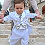 Gabriel a rejoint le concours — aidez-le/la à gagner de superbes lots ! child, toddler, white_suit, bow_tie, hands, adult, street, stone_pavement, outdoor, people, walking, building, door, casual_clothing, cute, portrait, fashion, formal_wear, expression, support