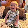 Wyatt joined the competition — help win amazing prizes! baby, bed, child, clothing, cute, dinosaur_onesie, fabric, footwear, furniture, happy, home, indoors, infant, light, person, pillow, portrait, sitting, smile, wooden_headboard
