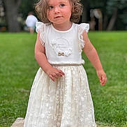 Alba participe au concours pour gagner de l'argent avec cette photo : toddler, child, girl, white_dress, curly_hair, outdoor, grass, trees, greenery, stone_path, portrait, summer, cute, innocence, young_child, fashion, footwear, standing, nature, daylight