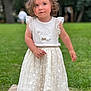 toddler, child, girl, white_dress, curly_hair, outdoor, grass, trees, greenery, stone_path, portrait, summer, cute, innocence, young_child, fashion, footwear, standing, nature, daylight